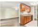 Open kitchen and living room area with hardwood floors and wooden cabinets for ample storage at 2375 S Linden Ct # 201, Denver, CO 80222
