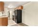Efficient kitchen with black appliances, wood cabinets, and tile flooring for easy maintenance at 2375 S Linden Ct # 201, Denver, CO 80222