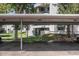 Assigned covered parking spaces for residents under labeled carport with green space, and a view of the building at 2375 S Linden Ct # 201, Denver, CO 80222