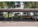 Assigned covered parking spaces for residents under labeled carport with green space, and a view of the building at 2375 S Linden Ct # 201, Denver, CO 80222