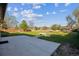 A spacious backyard featuring a concrete patio, lush lawn, mature trees, and a wooden fence at 16246 E Hamilton Pl, Aurora, CO 80013