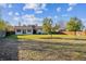 Large, green backyard featuring a well-maintained lawn, a variety of trees, and a charming house at 16246 E Hamilton Pl, Aurora, CO 80013