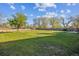 Expansive backyard with lush green grass, mature trees, and a wooden fence offering privacy at 16246 E Hamilton Pl, Aurora, CO 80013