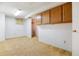 Unfinished basement area featuring carpet, painted walls, and wood cabinets for storage at 16246 E Hamilton Pl, Aurora, CO 80013