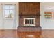 Close-up of the living room's brick fireplace with decorative mantel and bright windows at 16246 E Hamilton Pl, Aurora, CO 80013