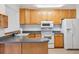 Functional kitchen features light wood cabinets, white appliances, and a contrasting gray countertop at 16246 E Hamilton Pl, Aurora, CO 80013