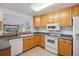 Kitchen features light wood cabinets, white appliances, and an open layout at 16246 E Hamilton Pl, Aurora, CO 80013