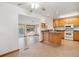 Open kitchen featuring light wood cabinets, modern appliances, and seamless flow into the dining area at 16246 E Hamilton Pl, Aurora, CO 80013