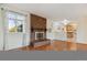 Spacious living room showcasing brick fireplace and open layout to the kitchen and dining areas at 16246 E Hamilton Pl, Aurora, CO 80013