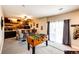 Basement wet bar with rustic wood accents, a foosball table, and a convenient sliding glass door for entertainment at 34942 Wagon Wheel Trl, Elizabeth, CO 80107