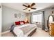 Bedroom with a ceiling fan and large bed with decorative pillows and an accent window at 34942 Wagon Wheel Trl, Elizabeth, CO 80107