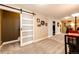 Spacious bonus room featuring neutral walls, plush carpeting, and sliding barn door at 34942 Wagon Wheel Trl, Elizabeth, CO 80107