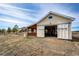 Detached garage exterior featuring a covered area, open garage door and lush surroundings at 34942 Wagon Wheel Trl, Elizabeth, CO 80107