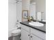 This bathroom features a shower and tub combo, a white vanity with dark counters, and modern fixtures at 11488 E 25Th Dr, Aurora, CO 80010