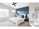 Comfortable main bedroom with large window, ceiling fan, and stylish accent wall at 11488 E 25Th Dr, Aurora, CO 80010