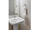 Stylish powder room featuring a pedestal sink, modern faucet, and decorative towel ring at 11488 E 25Th Dr, Aurora, CO 80010