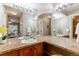 Bathroom with a granite countertop, double sink and a large mirror reflecting the interior at 9283 E Arbor Cir # C, Englewood, CO 80111