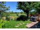 Charming backyard patio with a grill, stone pathway, lush lawn and a view of the pond at 2937 W Yarrow Cir, Superior, CO 80027