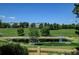 Serene backyard pond reflecting the sky, surrounded by lush greenery, and a quaint wooden fence at 2937 W Yarrow Cir, Superior, CO 80027