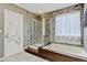 Stunning bathroom featuring a glass shower, soaking tub, and modern stone wall design, perfect for relaxation at 2937 W Yarrow Cir, Superior, CO 80027