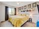 Cozy bedroom with a soft yellow bedspread, natural light, and decor enhancing a warm, inviting atmosphere at 2937 W Yarrow Cir, Superior, CO 80027