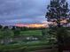 Scenic community view featuring a pond, lush greenery, and a vibrant sunset sky at 2937 W Yarrow Cir, Superior, CO 80027