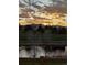 Scenic view of the community landscape featuring a pond, greenery, mountains and the sunset sky at 2937 W Yarrow Cir, Superior, CO 80027