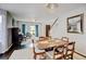 Bright dining area with wood table, white chairs, and modern chandelier, seamlessly connected to the living room at 2937 W Yarrow Cir, Superior, CO 80027