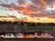 Picturesque sunset view over a tranquil pond and neighborhood, creating a serene and calming atmosphere at 2937 W Yarrow Cir, Superior, CO 80027