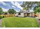 A spacious backyard with a lush lawn, a wooden fence, and a covered patio area at 1980 S Kearney Way, Denver, CO 80224