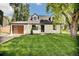 Charming home with a well-manicured lawn, classic white exterior, and a modern garage door at 1980 S Kearney Way, Denver, CO 80224