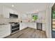 Modern kitchen featuring white cabinets, stainless steel appliances, and stylish hardware at 1980 S Kearney Way, Denver, CO 80224