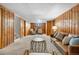 Cozy basement with a warm leather sofa, wood paneling, and plush carpeting, perfect for relaxation at 1295 Elm St, Denver, CO 80220