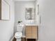 Stylish powder room featuring a modern vanity with sleek hardware and a framed mirror at 1295 Elm St, Denver, CO 80220