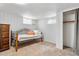 A carpeted bedroom has a narrow bed with orange pillows and a dark wood dresser, as well as a closet at 1295 Elm St, Denver, CO 80220