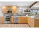 Updated kitchen with stainless steel appliances, granite counters, wood cabinets, and hardwood flooring at 1295 Elm St, Denver, CO 80220
