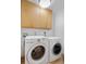 Clean and functional laundry area with front-load washer and dryer and ample cabinet storage at 1295 Elm St, Denver, CO 80220