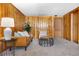 Cozy living room with wood-paneled walls, leather couch, stylish side tables, and soft carpet at 1295 Elm St, Denver, CO 80220