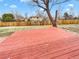 Large backyard featuring a spacious deck, a wooden fence, and mature trees at 3118 S Joplin Ct, Aurora, CO 80013