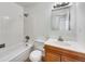 Bathroom with a shower/tub combo, tiled walls, a vanity with storage, and a neutral color scheme at 3118 S Joplin Ct, Aurora, CO 80013