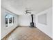 Bright living room featuring a wood burning stove, a ceiling fan, and a large window at 3118 S Joplin Ct, Aurora, CO 80013