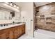 Bathroom featuring a wooden vanity, matching mirror, a tiled shower and tub combo at 2023 S Rifle St, Aurora, CO 80013