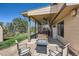 Covered patio with fire pit, ceiling fans, swing, grill, and seating for outdoor relaxation at 2023 S Rifle St, Aurora, CO 80013