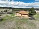 Aerial view of cozy home with lawn under partly cloudy sky, surrounded by mature trees and distant hills at 3840 Sierra Vista Rd, Monument, CO 80132
