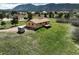Aerial view of a home on a large lot surrounded by green lawns and treed mountain views at 3840 Sierra Vista Rd, Monument, CO 80132