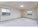 An empty bedroom with carpet, neutral walls, and large windows providing natural light at 3840 Sierra Vista Rd, Monument, CO 80132