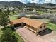 A single-story home with a brown roof and stucco exterior, nestled in a verdant landscape with mountain views at 3840 Sierra Vista Rd, Monument, CO 80132