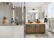 Modern bathroom featuring a tiled shower with glass doors and double vessel sinks at 3930 S Argonne Way, Aurora, CO 80013