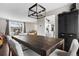 Well-lit dining area with modern lighting, a spacious table, and views into the living room and kitchen at 3930 S Argonne Way, Aurora, CO 80013