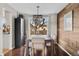 Stylish dining area with wood floors, a modern light fixture, a wood accent wall, and large windows at 3930 S Argonne Way, Aurora, CO 80013